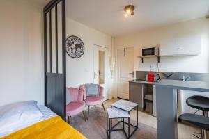 een kleine kamer met een bed en een keuken bij Bistrot 10 in Nazelles