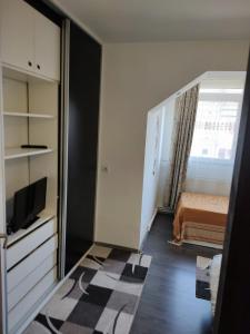 Cet appartement comprend une chambre avec un lit et une télévision. dans l'établissement white black rooms, à Hunedoara