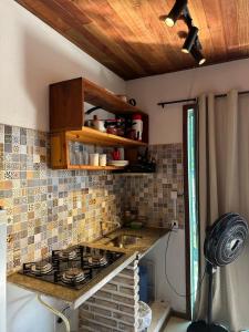 a kitchen with a sink and a stove top oven at Apartamentos Mandala in Itacaré