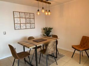 a dining room with a wooden table and chairs at Departamento Playa Herradura Primera Línea in Coquimbo