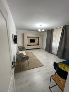 sala de estar con silla y TV en Apartament 2 camere ultracentral en Giurgiu