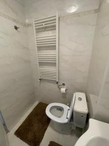 a white bathroom with a toilet and a sink at Apartament 2 camere ultracentral in Giurgiu