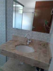 a bathroom counter with a sink and a mirror at CONDÓMINIO BEIRA RIO in Canindé de São Francisco