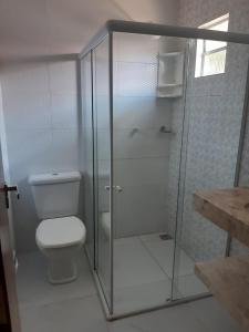 uma casa de banho com um WC e uma cabina de duche em vidro. em CONDÓMINIO BEIRA RIO em Canindé de São Francisco