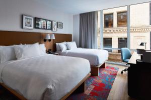 ニューヨークにあるHotel Indigo NYC Financial District, an IHG Hotelのベッド2台と窓が備わるホテルルームです。