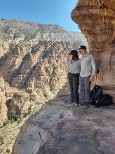 a man and woman standing on top of a mountain at Feynan wild camp in Al Khuraybah