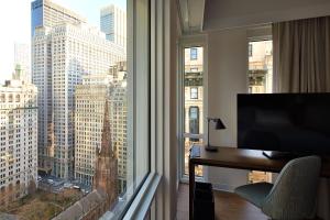 a room with a desk and a large window with a view at Hotel Indigo NYC Financial District by IHG in New York