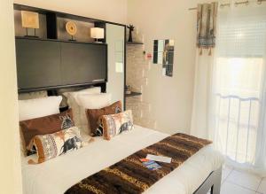 a bedroom with a large bed with pillows on it at Hôtel Le Méditerranée in Hyères