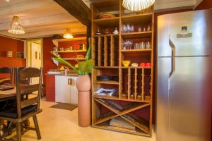 a kitchen with a stainless steel refrigerator and a table at Vila Patí Caraíva in Caraíva