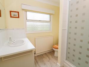 a bathroom with a sink and a window and a toilet at Trevow in Camborne