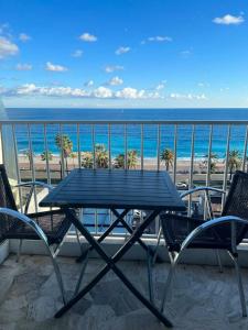 un tavolo e sedie su un balcone con vista sulla spiaggia di Appartement d'une chambre a Nice a 200 m de la plage avec vue sur la mer terrasse et wifi a Nizza