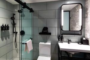 a bathroom with a toilet and a sink and a mirror at Hotel Indigo NYC Financial District, an IHG Hotel in New York