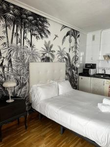 - une chambre avec un lit et du papier peint tropical dans l'établissement Estudio en la calle mas bonita de salamanca, à Salamanque