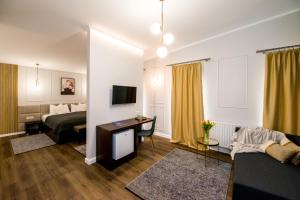 a living room with a bed and a desk in a room at Hotel Ramina in Timişoara