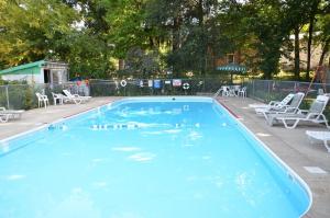 a large blue swimming pool with white chairs and tables at Deer trail Motel in Wisconsin Dells