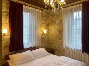 a bedroom with a bed and two windows at Dionysos 1789 Boutique Hotel in Foca