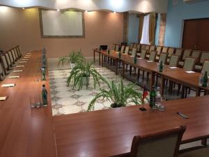 una sala de conferencias con mesas y sillas de madera largas en Vayk Hotel, en Vaykʼ