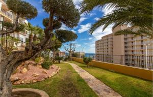 une passerelle avec un palmier et un bâtiment dans l'établissement Nice Apartment In Santa Pola With Outdoor Swimming Pool, à Santa Pola
