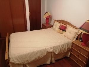 een slaapkamer met een groot bed met witte lakens en kussens bij La maison de la mer in Setúbal