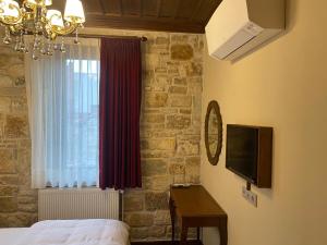 um quarto com uma cama, uma janela e uma secretária em Dionysos 1789 Boutique Hotel em Foça