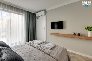 una camera da letto con un letto e una TV a parete di MS Apartments Rest 1.0 a Sopot Altre 5 foto