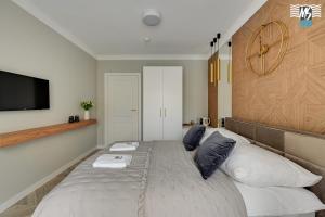 a bedroom with a large bed with a tv on the wall at MS Apartments Rest 1.0 in Sopot