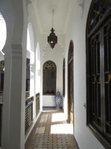 a hallway of a house with a vase on the floor at Riad Arous Chamel in Tangier