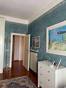 een kamer met een witte ladekast en een schilderij aan de muur bij casa Monia in Roe