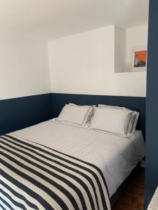 a bedroom with a bed with a striped blanket on it at Heir Island House in Skibbereen