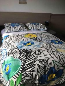a bed with a floral comforter in a bedroom at Studio Golf piscine D Day in Port-en-Bessin-Huppain