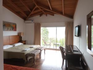 a bedroom with a bed and a table and a television at Tagore Suites Hotel in Villa Carlos Paz +24 photos
