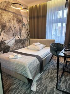 Habitación de hotel con cama y silla en Willa Joker en Nowy Dwór Gdański