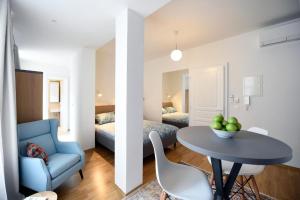 a room with a table and a blue chair and a bedroom at City Centre Chic Apartment Ljubljana 2/4 in Ljubljana