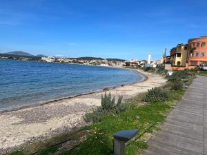 a beach next to the water with buildings at Ampio monolocale in Golfo Aranci