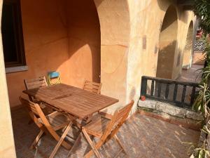 a wooden table and chairs outside of a building at Ampio monolocale in Golfo Aranci +14 photos