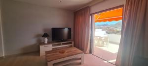 a living room with a television and a balcony at La colina in Arona