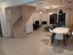 a living room with a staircase and a table and chairs at Rahoni amazing view in Pefkochori