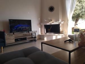 a living room with a tv and a coffee table at Rahoni amazing view in Pefkochori