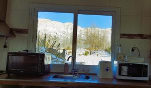 a kitchen counter with a microwave and a window at Starry Lodge in Ciudad Lujan de Cuyo