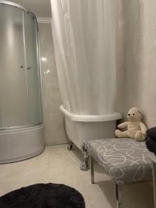 a bathroom with a tub and a teddy bear sitting on a bench at E & A LOSSI 21/23 in Tartu