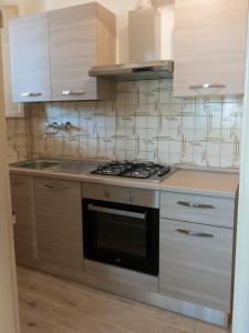 a kitchen with a stove and a sink at Il Glicine in Falerone