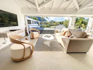 a living room with a couch and chairs at Acacia Tropical, luxurious Duplex, walkable beach in Anse Marcel 