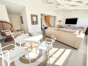sala de estar con sofá, mesa y sillas en Acacia Tropical, luxurious Duplex, walkable beach, en Anse Marcel 