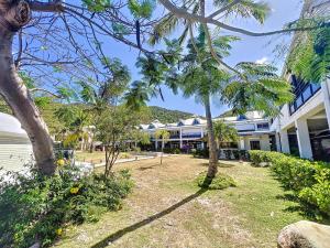 a building with palm trees in front of it at Acacia Tropical, luxurious Duplex, walkable beach in Anse Marcel 