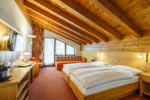 ein Schlafzimmer mit einem großen Bett in einem Holzzimmer in der Unterkunft Hotel Alpenroyal in Zermatt