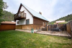 a house with a deck and a backyard at Our Red River Cabin With High Speed Wifi in Red River