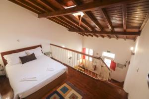 a small bedroom with a bed and a staircase at Casa 22 in Lagos