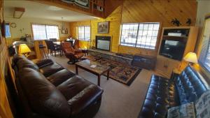 a living room with a leather couch and a television at Our Red River Cabin With High Speed Wifi in Red River