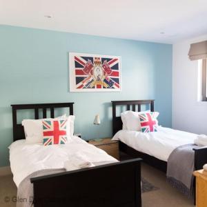 two beds in a room with blue walls at Number 4 Steading Cottage in Banchory