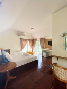 ชอว์ งาทอง รีสอร์ต Chor Ngar Thong Erawan في مدينة كانشانابوري: غرفة نوم بسرير وطاولة في غرفة